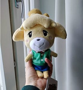 Plushie of Animal Crossing character Isabelle sitting on a person's hand.