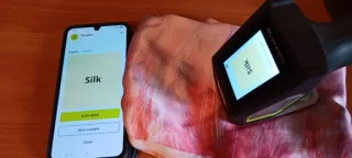 Käsikäyttöinen tekstiili- ja muovianalysaattori analysoi silkkihuivini.