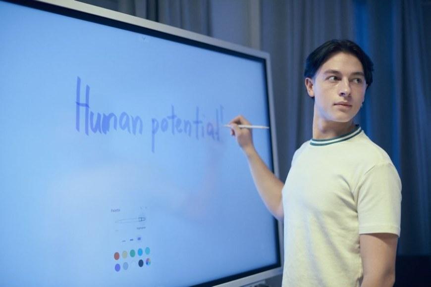 Opiskelija kirjoittaa älytaululle Human potential.