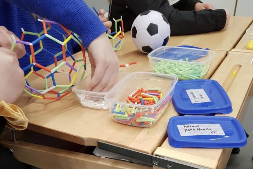 Oppilaita rakentamassa 4D-jalkapalloja ajattelun ja oppimaan oppimisen taitoja kehittävässä matematiikkapajassa.
