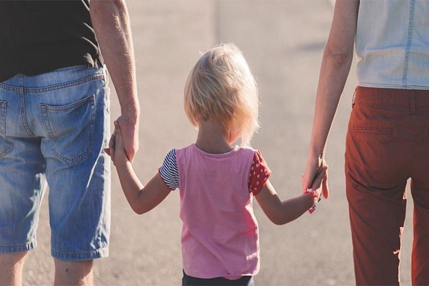 Kuvassa isä, lapsi ja äiti kävelemässä. Kuva:Pixabay