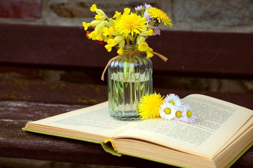 Keltaisia kukkia ja avattu kirja