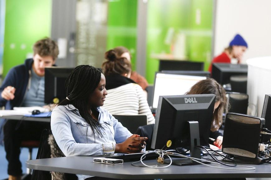 Opiskelijat opiskelevat tietokoneilla opetusluokassa.