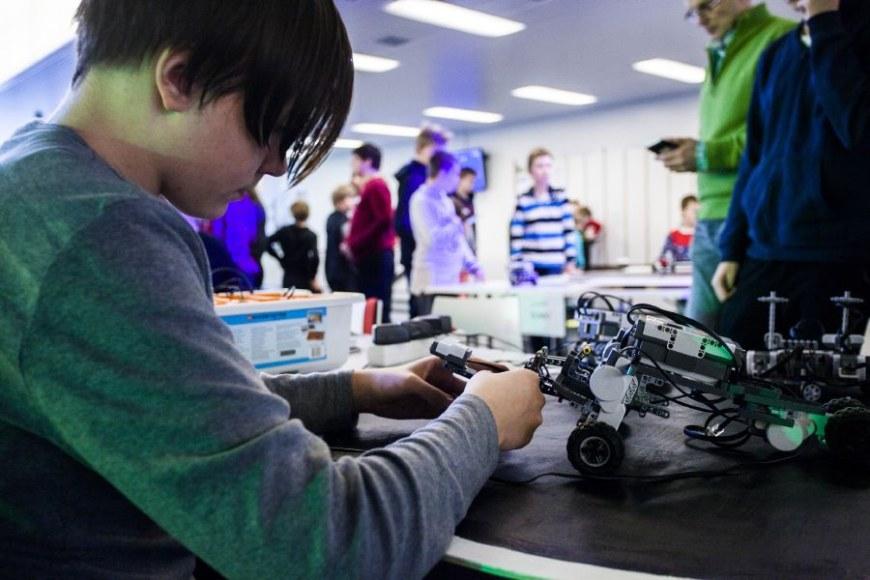 Koululainen rakentaa robottia koulun tiedetunnilla