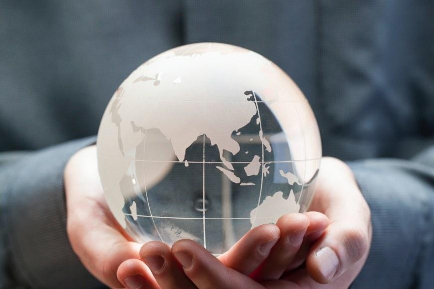 A person holding a glass globe in their hands.