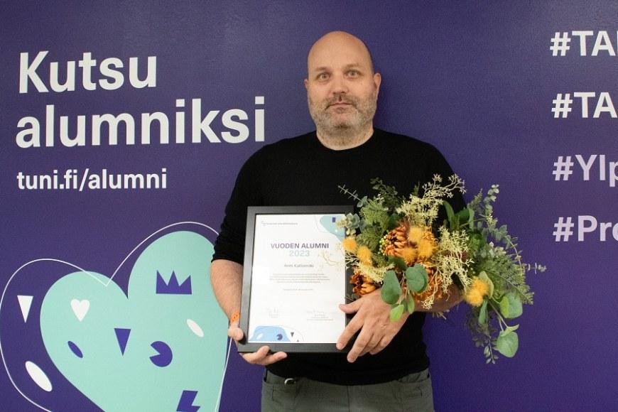 Vuoden alumni 2023 Antti Kalliomäki kukkien ja ja diplomin kanssa kuvattuna.