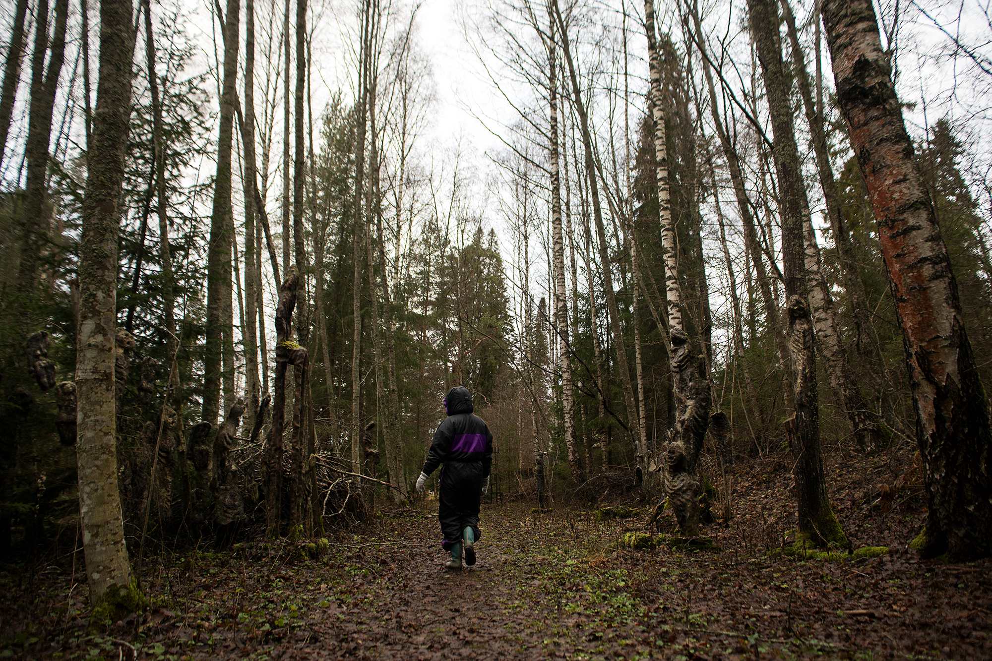 toppahaalareissa kävelijä Ossi Somman veistospuistossa, selkä kameraan