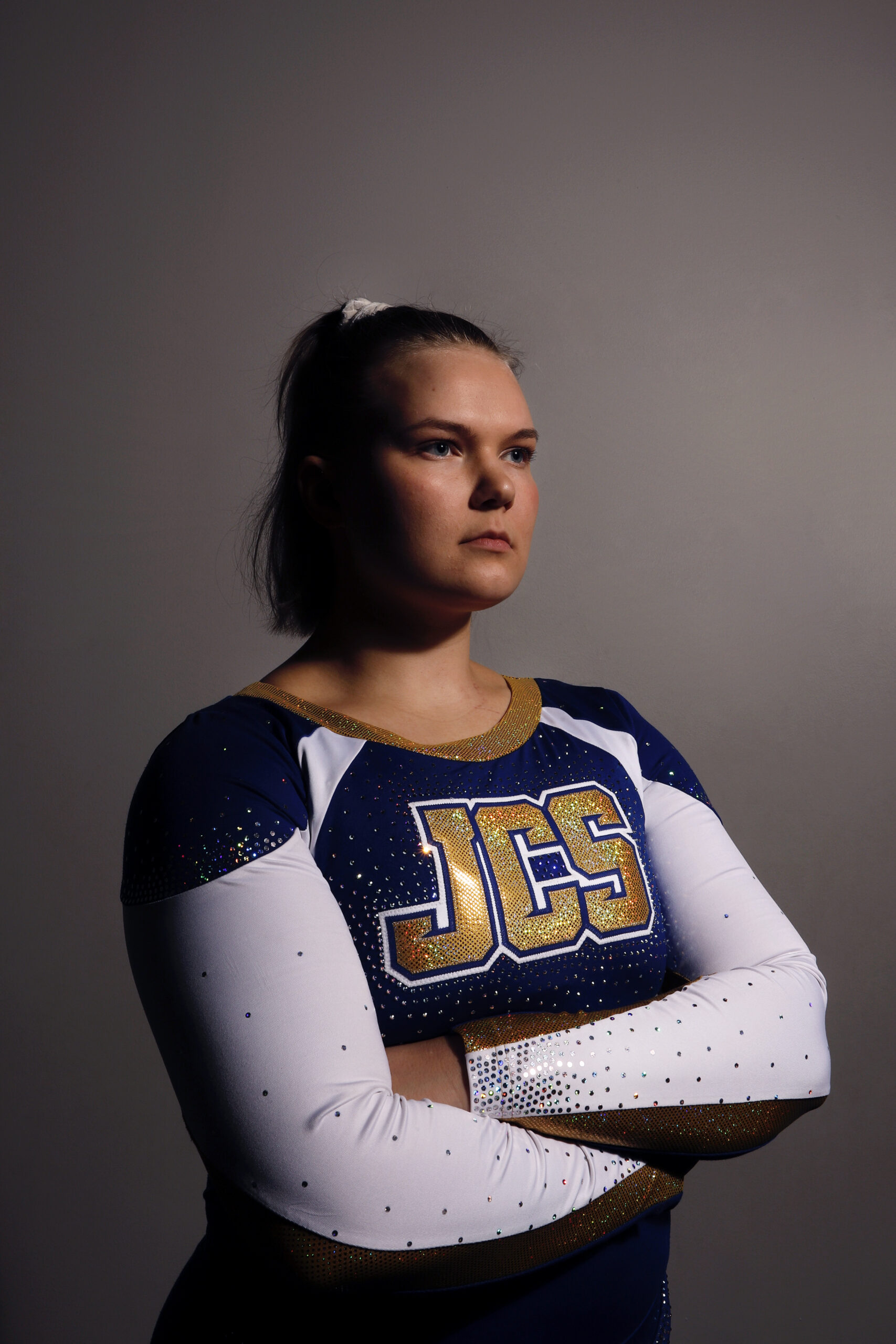 Cheerleader poseeraa urheiluhallissa.