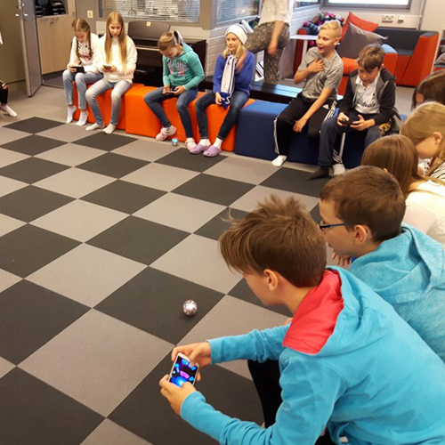 Kuva KAKS10 56 -oppimisympäristöstä. Kuvassa oppilaita ohjaamassa Sphero-robottipalloja avoimessa Katsomo-tilassa.