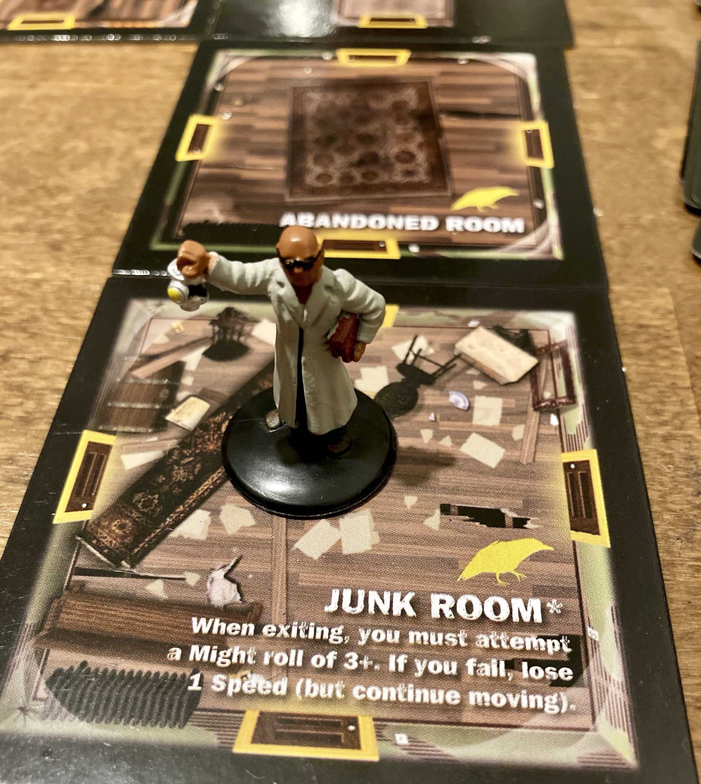 A character pawn standing on a game tile titled Junk Room. 