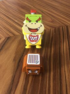 A smiling Bowser Junior and a grimacing Goomba figurines.