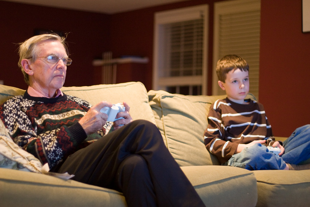 An older adult playing video games with a child