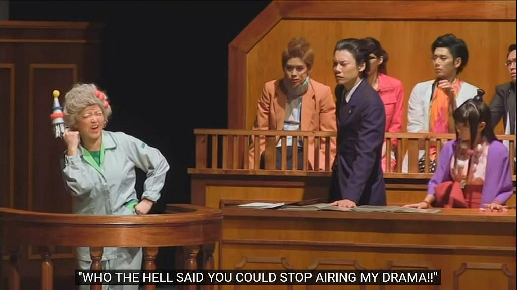 On the left, an older lady, witness to the crime, is giving an inconherent and irrelevant statement as the defense attorney and his assistant on the right listen