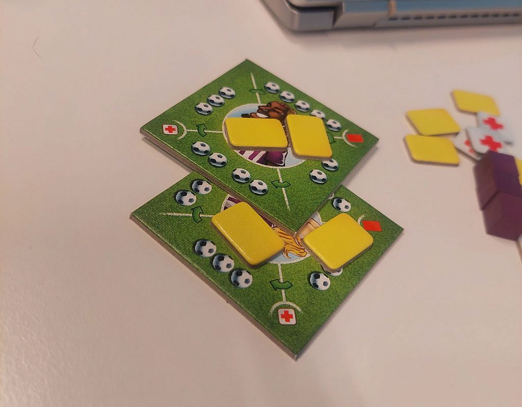 Two footballer cards with two yellow cards on top of both