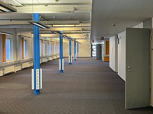 Blue pillars and an open door in a large office space.