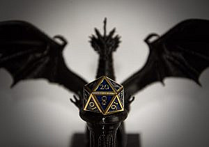 Golden Blue twenty-sided Die (D20) in front of Dragon Statue, blurry background and die presented on a pedastal and in focus