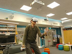A man playing a game with a virtual reality headset.