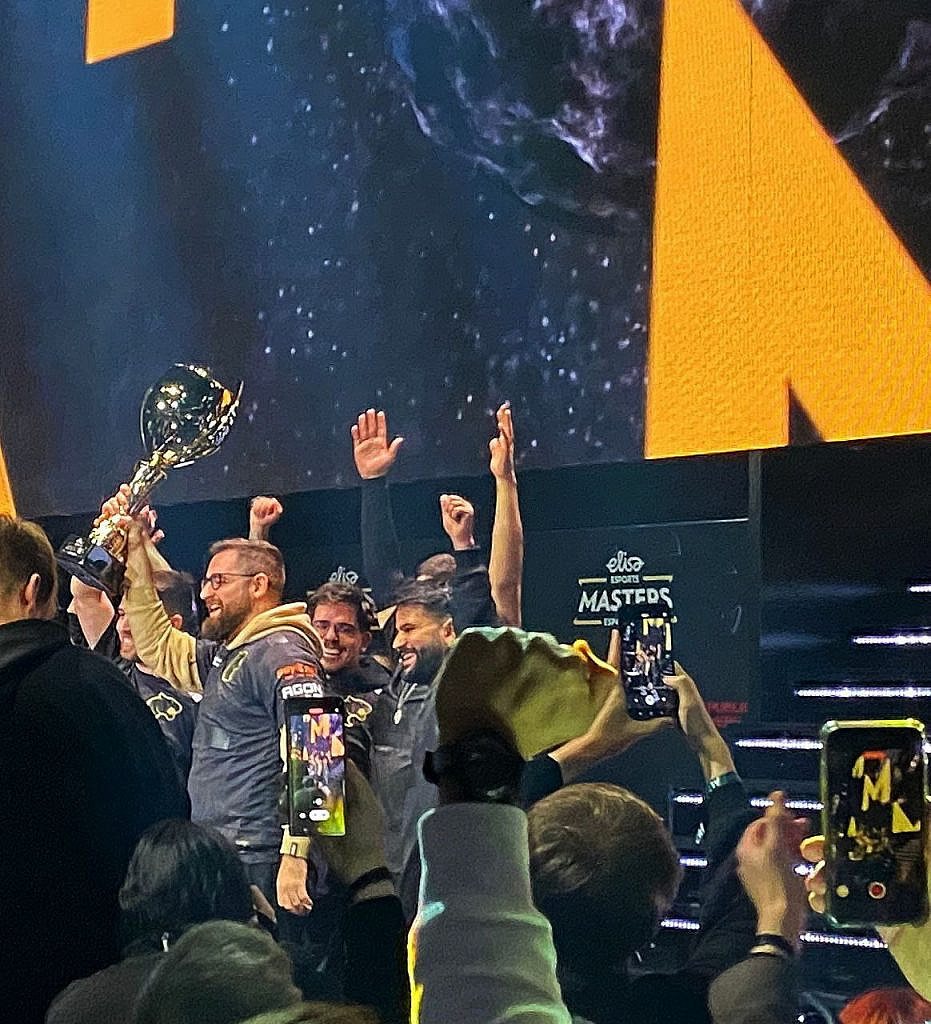 Team lifting the trophy on stage
