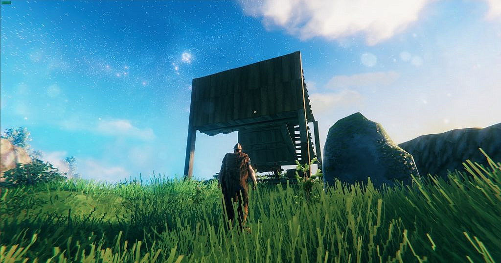 A viking looking towards unfinished wooden building.