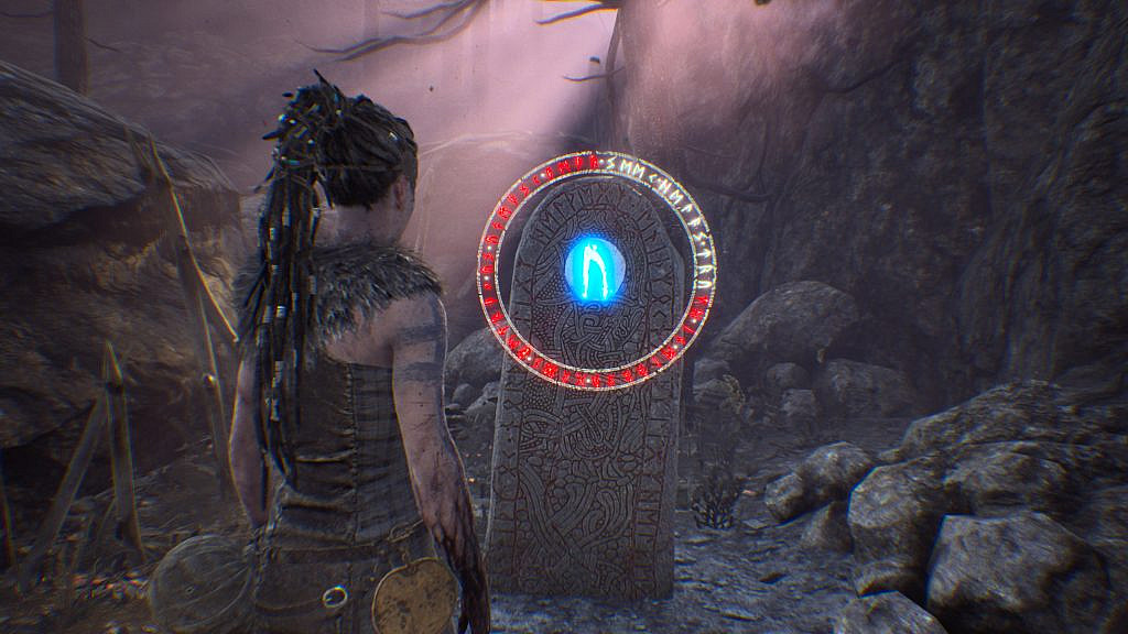 Woman looking at a standing stone with one big rune and small runes around the big one.