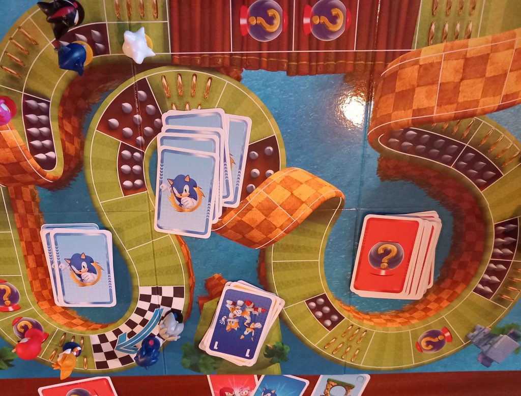 Sonic Super Teams gameboard with a racetrack, two stacks of cards and character tokens.