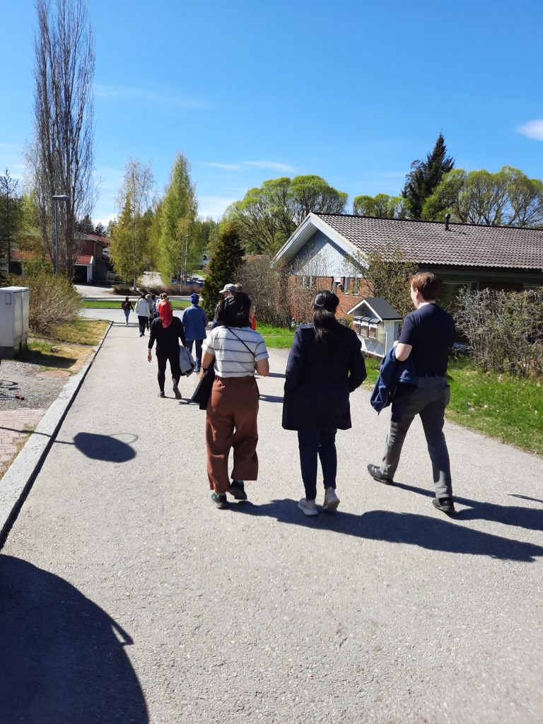 The group of people walking on a suburban street.